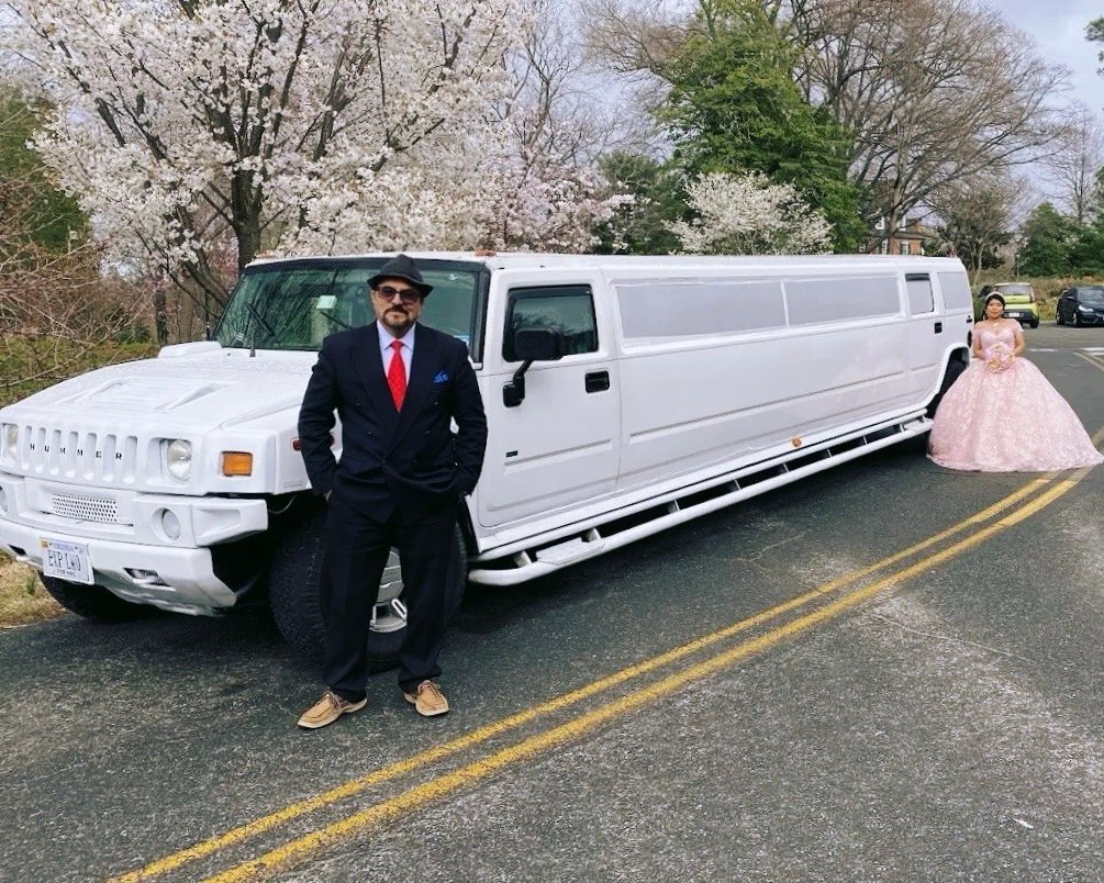 Chauffeur opening door for VIP client in black SUV limo